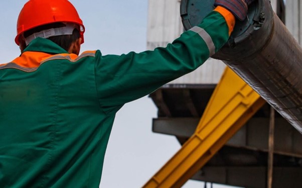 Man standing next to drill rig.